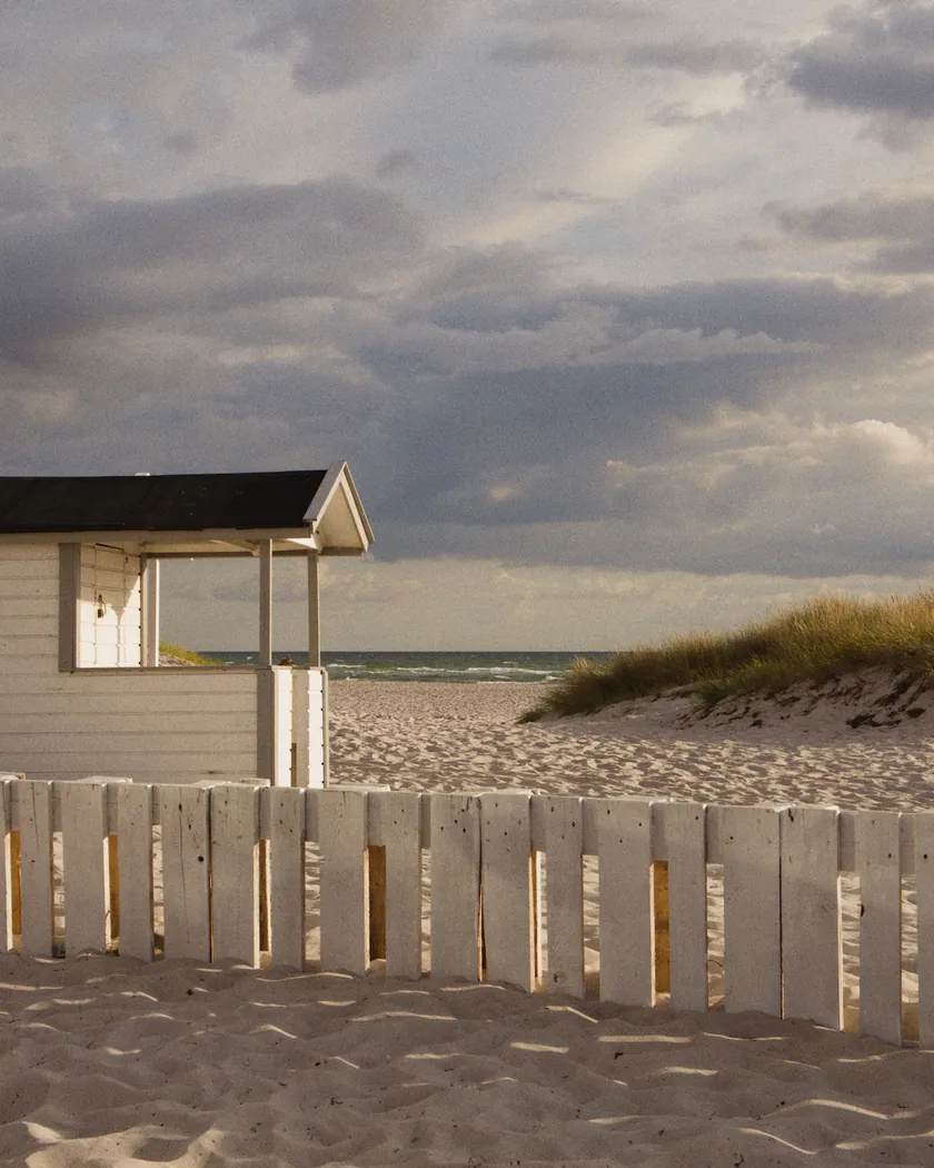 After: beach cabin under storm clouds, with the preset inspired by Agfa Vista 400 (GA — 070 / P) applied (simulation).