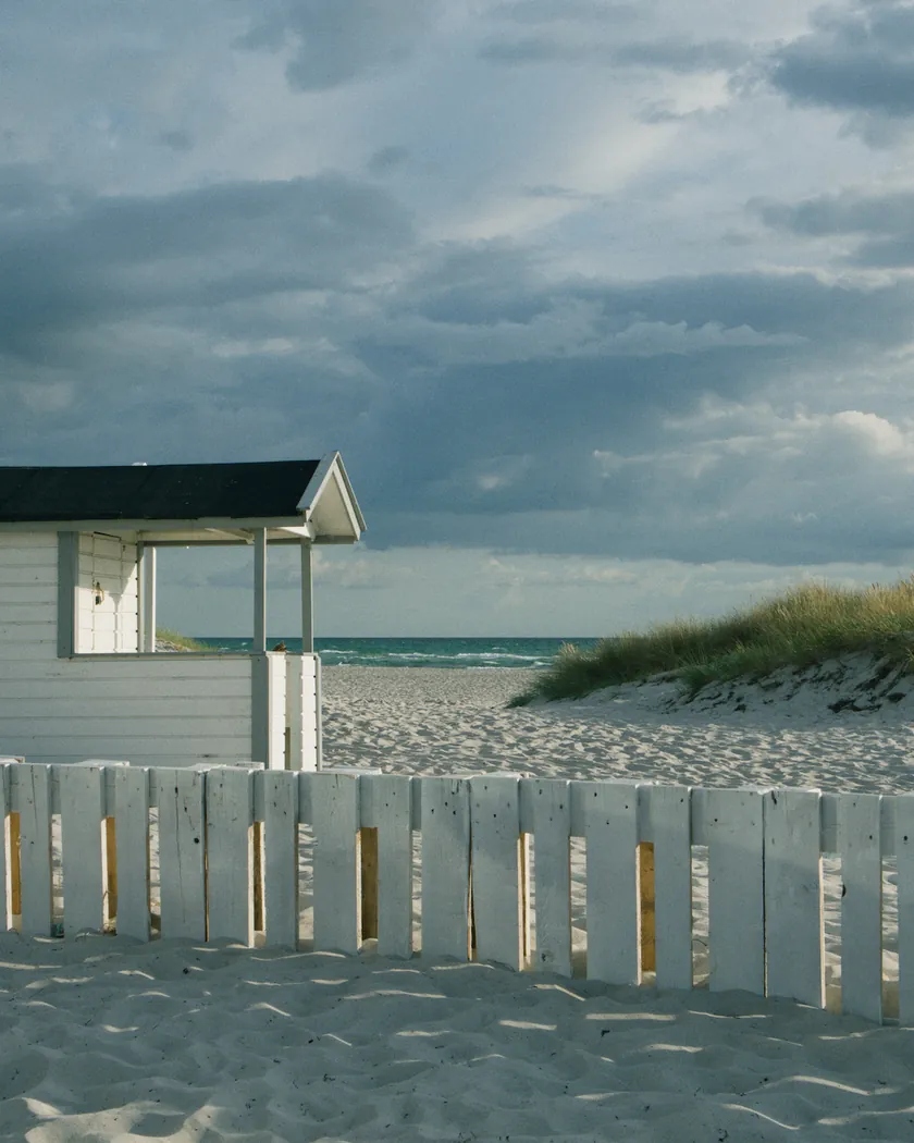 After: beach cabin under storm clouds, with the preset inspired by Fujifilm Fujicolor C200 (GA — 068 / P) applied (simulation).