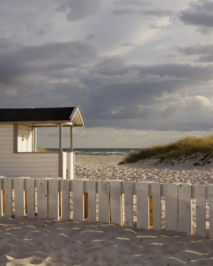 After: beach cabin under storm clouds, with the preset inspired by Fujifilm Sensia 100 (GA — 078 / P) applied (simulation).
