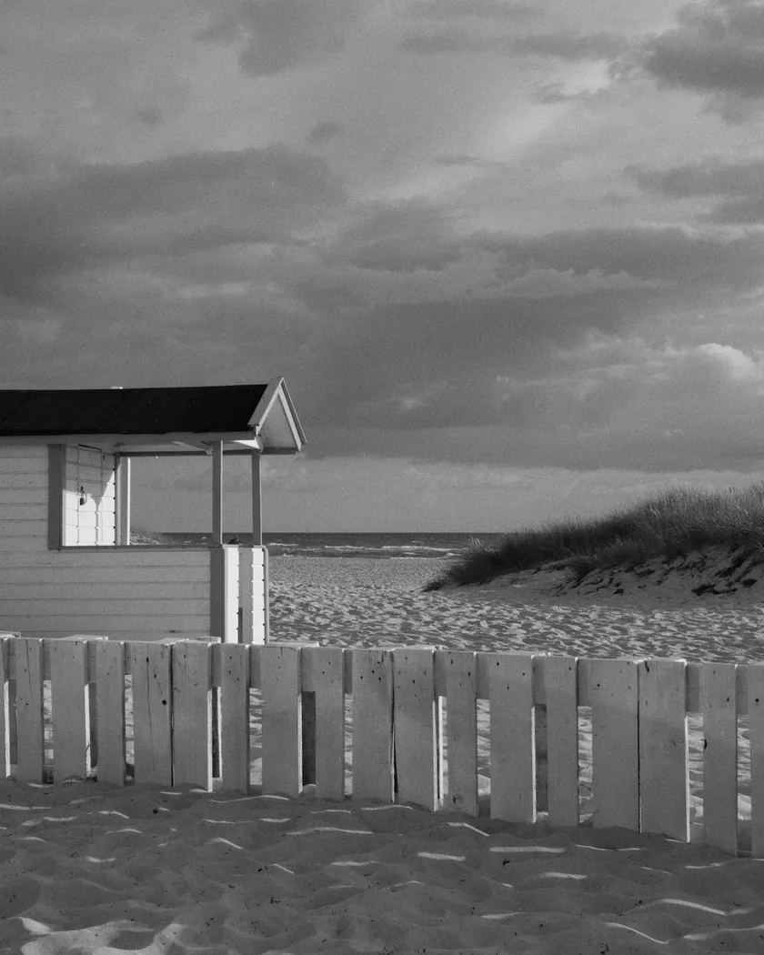 After: beach cabin under storm clouds, with the preset inspired by Kodak Tri-X 320 (GA — 082 / P) applied (simulation).
