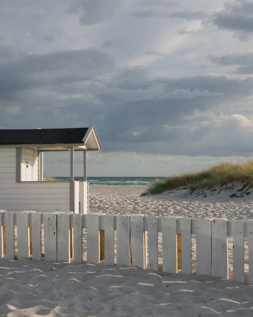 Beach cabin under storm clouds, with the preset inspired by Fujifilm Pro 400H (GA — 002 / P) applied (simulation).