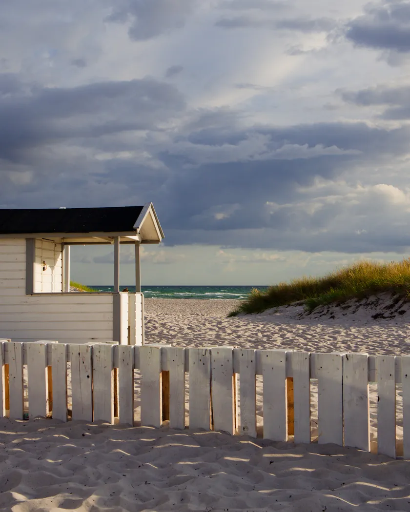 Beach cabin under storm clouds, with the preset inspired by Fujifilm Velvia 50 (GA — 014 / P) applied (simulation).