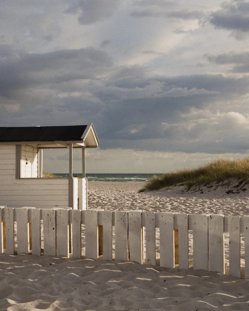 Beach cabin under storm clouds, with the preset inspired by Kodak UltraMax 400 (GA — 009 / P) applied (simulation).